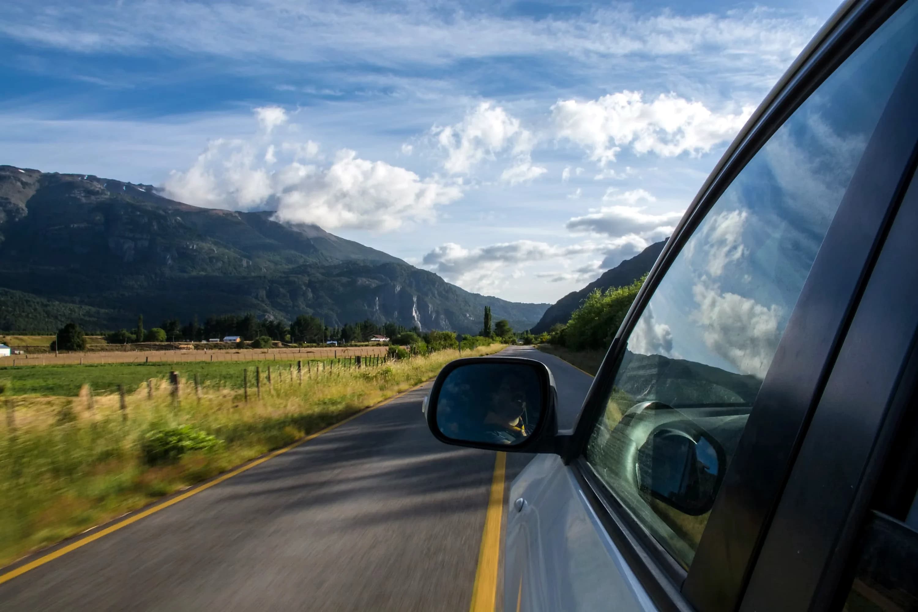 Vue depuis une voiture MDA CAR roulant sur une route de montagne, illustrant la liberté de conduire dans la région